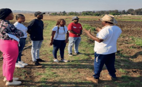 TVET students listening to a supervisor in a field